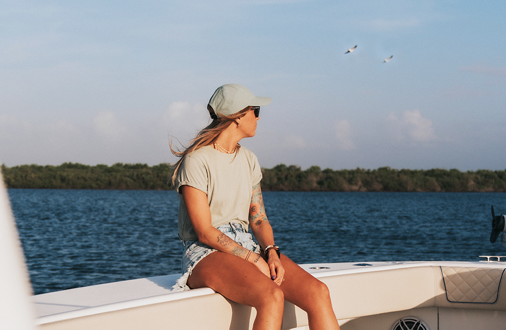 image of a guest sitting on the side of the Change 'N Latitude's SeaVee 370z looking at the water