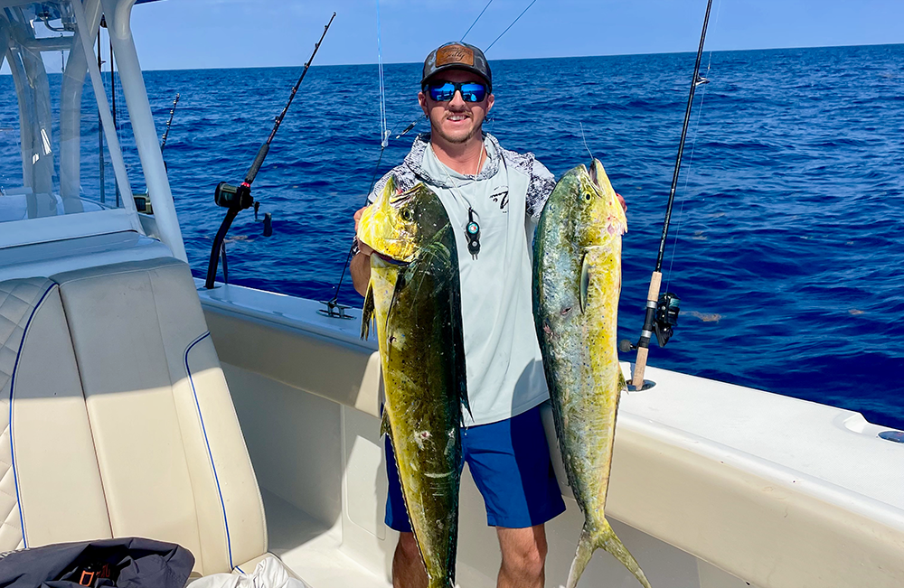guest holding mahi-mahi that was caught while on a fishing charter with Changes 'N latitude